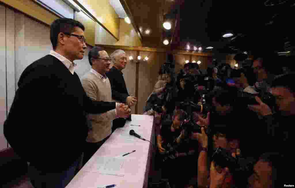 Photographers are seen taking pictures as Occupy Central civil disobedience founder Benny Tai (center), a law professor at the University of Hong Kong, along with the co-founders of Hong Kong&#39;s Occupy Central civil disobedience movement, called on pro-democracy activists to pull back from the city&#39;s main protest site next to government headquarters and said they will surrender to police, Hong Kong, Dec. 2, 2014.