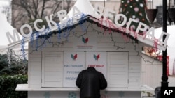A man stands in front of a closed small shop called "Moscow - Belgrade", on the main pedestrian street in downtown Belgrade, Serbia, Jan. 16, 2023.