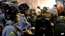 A protester yells at a Missouri State Police officer during a protest at the Ferguson, Missouri, police headquarters, Oct. 10, 2014.