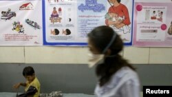 A nurse walks past as a child sitting at Medecins Sans Frontieres Holland's clinic in Rangoon, March 3, 2014.