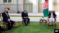 FILE - Afghan President Ashraf Ghani, right, and fellow leader Abdullah Abdullah, center, meet with U.S. peace envoy Zalmay Khalilzad at the Presidential Palace, in Kabul, May 20, 2020.