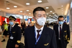 China Eastern Airlines flight crew wear protective masks on arrival at Sydney International Airport in Sydney, Australia, Jan. 23, 2020.