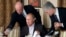 FILE - In this Nov. 11, 2011, photo, businessman Yevgeny Prigozhin, left, serves food to Russian Prime Minister Vladimir Putin, center, during dinner at Prigozhin's restaurant outside Moscow, Russia. 