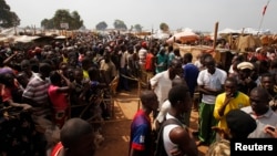 People displaced by the recent unrest, wait to collect food distributed by aid agencies at an IDP camp at the Mpoko International Airport of Bangui, Central African Republic, Feb. 12, 2014.