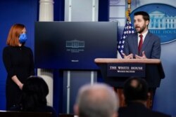 FILE - White House press secretary Jen Psaki listens as National Economic Council Director Brian Deese speaks during a press briefing at the White House, Jan. 22, 2021, in Washington.