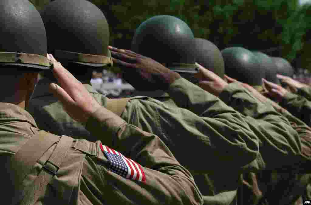 World War II reenactors salute while the National Anthem plays during ceremony commemorating 70th Anniversary of VE Day at the National World War II Memorial, May 8, 2015, in Washington, D.C.