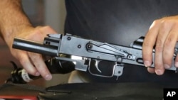 Clark Aposhian, chairman of the Utah Shooting Sports Council, demonstrates how a little-known device called a "bump stock" is attached to a semi-automatic rifle at the Gun Vault store and shooting range Wednesday, Oct. 4, 2017, in South Jordan, Utah. 