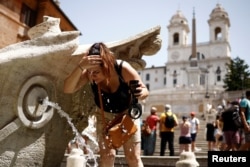 Seorang perempuan mendinginkan diri di Fontana della Barcaccia di Tangga Spanyol, Roma, Italia saat gelombang panas melanda negara itu, 17 Juli 2023. (REUTERS/Guglielmo Mangiapane)