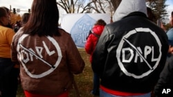 Cousins Jessica and Michelle Decoteau of Belcourt, both enrolled members in the Turtle Mountain Band of Chippewa, don slogans opposing the Dakota Access Pipeline in Bismarck, N.D., Oct. 29, 2016.