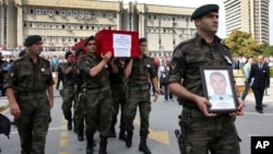 FILE - Turkish police officers carry the coffin of Turkish police special operations officer Sahin Polat Aydin, one of the four officers killed in a landmine attack attributed to PKK militants in Silopi, southeastern Turkey, during a ceremony in Ankara, Aug. 11, 2015.