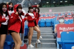 Cheerleaders take group photos with face masks on at the first professional baseball league game of the season at Taoyuan International baseball stadium in Taoyuan city, Taiwan, April 11, 2020.