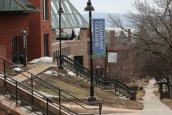 FILE - A sign on the empty campus of Champlain College in Burlington, Vermont, March 11, 2020.