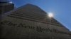 FILE - The sun peaks over the New York Times building in New York, Aug. 14, 2013. 