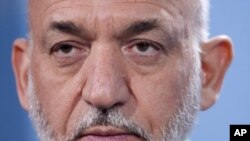 Afghan President Hamid Karzai during a news conference with German Chancellor Angela Merkel after a meeting at the chancellery in Berlin, December 6, 2011.