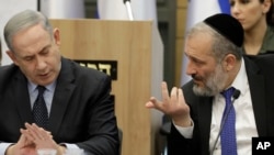 Israeli Prime Minister Benjamin Netanyahu listens to Israeli Interior Minister Aryeh Deri during a meeting with his nationalist allies and his Likud party members, at the Knesset, Israeli Parliament, in Jerusalem, March 4, 2020. 