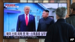 FILE - People in the Seoul, South Korea, Railway Station watch a TV screen showing North Korean leader Kim Jong Un and U.S. President Donald Trump during a news program, Dec. 31, 2019. 