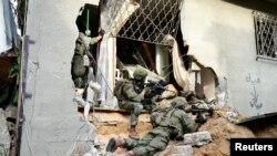 Israeli soldiers operate at the Shajaiya district of Gaza City amid the ongoing conflict between Israel and the Palestinian Islamist group Hamas, in the Gaza Strip.