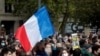 People gather at the Place de la Republique in Paris, to pay tribute to Samuel Paty, the French teacher who was beheaded on the streets of the Paris suburb of Conflans-Sainte-Honorine, Oct. 18, 2020. 