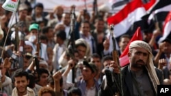 A Shi'ite Houthi rebel holds up his weapon during a rally against Saudi-led airstrikes in Sana'a, Yemen, June 14, 2015.