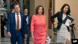 House Speaker Nancy Pelosi of Calif., center, walks towards the House Chamber on Capitol Hill, Jan. 15, 2020, in Washington. 