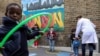 Children use hoops for social distancing at L'Ecole des Petits, an independent French bilingual school, as the coronavirus disease (COVID-19) lockdown eases in Fulham, London, June 9, 2020. 