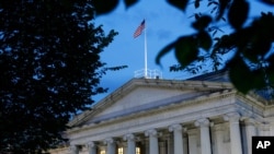 FILE - This June 6, 2019, photo shows the U.S. Treasury Department building at dusk in Washington. 