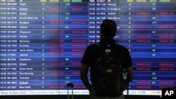 Papan informasi menampilkan pembatalan jadwal penerbangan setelah pemerintah Malaysia menutup perbatasannya untuk membendung perebakan virus corona (COVID-19), di Bandara Internasional Kuala Lumpur di Sepang, Malaysia, 18 Maret 2020.