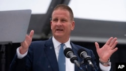 In this photo provided by University of Massachusetts Dartmouth, billionaire Robert Hale speaks at the graduation ceremony May 16, 2024, in Dartmouth, Mass. Hale gifted graduates at the University of Massachusetts Dartmouth each with $1,000, but he asked them to donate $500.