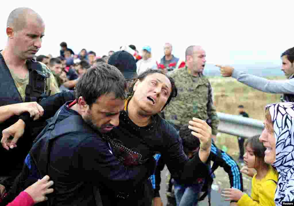A group of migrants try to go through police blockades at Gevgelija, in Macedonia, after crossing the border from Greece. Macedonia is considering building a Hungarian-style border fence to stem a rising influx of migrants from the south, Foreign Minister Nikola Poposki was quoted as saying.
