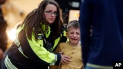 Para petugas membimbing para siswa turun dari bus dan mengarahkannya ke pusat rekreasi dimana mereka dipersatukan kembali dengan para orang tuanya setelah insiden penembakan di sebuah sekolah di Highland Ranch, Denver, Colorado, 7 Mei 2019 (foto: AP Photo/David Zalubowski)