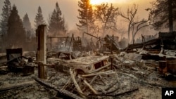 A vintage car rests among debris as the Camp Fire tears through Paradise, Calif., on Nov. 8, 2018. 