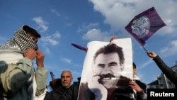 তুরস্কের দিয়ারবাকিরে এক প্রতিবাদ সমাবেশে কারাগারে আটক কুর্দি বিদ্রোহী নেতা আব্দুল্লাহ ওচালানের একটি ছবি হাতে ধরে একজন বিক্ষোভকারী, ২৭ ফেব্রুয়ারি, ২০২৫। 
