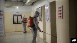 Members of a humanitarian aid agency disinfect Ibn Sina hospital as prevention against coronavirus in Idlib city, Syria, March 19, 2020. 