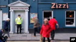 FILE - A police officer stands outside an Italian restaurant in Salisbury, England, March 6, 2018, near the spot where former Russian double agent Sergei Skripal and his daughter were found critically ill March 4 following exposure to an "unknown substance," later reported to be a nerve agent.