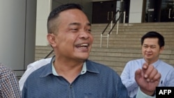 FILE - Jatuporn Prompan (foreground), leader of the Thai opposition "Red Shirt" movement, speaks to supporters at the Criminal Court in Bangkok, Thailand, Jan. 28, 2015.