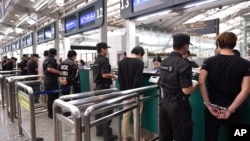 แฟ้มภาพ (สำนักข่าวซินหัว) - เจ้าหน้าที่จีนนำตัวผู้ต้องหาจากแก๊งคอสเซนเตอร์ในเอเชียตะวันออกเฉียงใต้ ผ่านกองตรวจคนเข้าเมืองที่สนามบินในเมืองกว่างโจว มณฑลกวางตุ้ง เมื่อวันที่ 10 พ.ย. ปี 2015