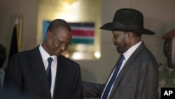 South Sudan's First Vice President Taban Deng Gai, left, speaks with President Salva Kiir, right, after Taban was sworn in, replacing opposition leader Riek Machar, at the presidential palace in Juba, South Sudan, Tuesday, July 26, 2016.