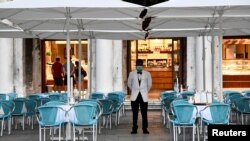 People gather outdoors at dusk on a viewpoint in Barcelona, Spain, July 25, 2020. Britain is advising people not to travel to Spain following a surge of COVID-19 cases.