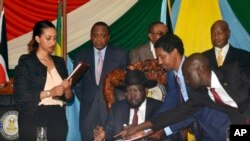 FILE - S. Sudan President Salva Kiir, seated, signs a peace deal as Kenya’s President Uhuru Kenyatta, center-left, Ethiopia’s Prime Minister Hailemariam Desalegn, center-right, and Uganda’s President Yoweri Museveni, right, look on in Juba, S. Sudan, Aug. 26, 2015.