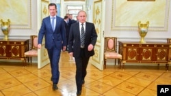 In this photo taken on Tuesday, Oct. 20, 2015, Russian President Vladimir Putin, right, and Syria President Bashar Assad arrive for their meeting in the Kremlin in Moscow, Russia. 