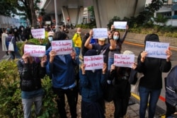 Pro-democracy supporters hold up posters outside West Kowloon Court after Joshua Wong, Agnes Chow and Ivan Lam were sentenced to jail, Dec. 2, 2020. (Tommy Walker/VOA)