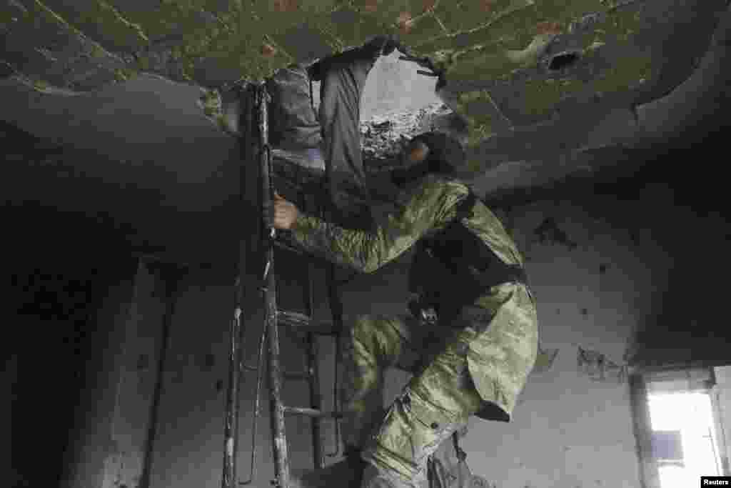 Rebel fighters climb a ladder as they move inside a damaged building where they take positions during clashes with forces loyal to Syria's President Bashar al-Assad, who are stationed in Aleppo's historic citadel, Dec. 7, 2014.