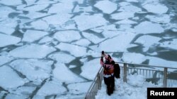 A pedestrian stops to take a photo by Chicago River, as bitter cold phenomenon called the polar vortex has descended on much of the central and eastern United States, in Chicago, Illinois, U.S., January 29, 2019.