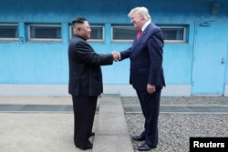 แฟ้มภาพ - อดีตปธน.โดนัลด์ ทรัมป์ จับมือกับ คิม จอง อึน ผู้นำเกาหลีเหนือ ที่เขตปลอดทหารระหว่างสองเกาหลี เมื่อ 30 มิ.ย. 2562