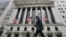 FILE - People walk by the New York Stock Exchange, June 24, 2016.