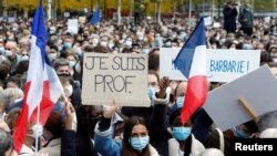 People gather at the Place de la Republique in Paris, to pay tribute to Samuel Paty, the French teacher who was beheaded on the streets of the Paris suburb of Conflans-Sainte-Honorine, France, Oct. 18, 2020. Placard reads "I am a teacher". (Reuters)