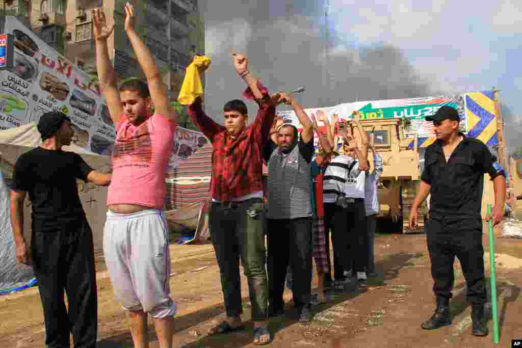 Pasukan keamanan Mesir menahan para demonstran saat membubarkan aksi duduk oleh para pendukung presiden terguling Mohamed Morsi di Kairo.&nbsp;(AP/Ahmed Gomaa)