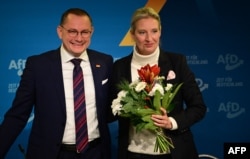 FILE - Alice Weidel, co-leader of Germany's far-right Alternative for Germany party, holds a bouquet of flowers she was given by party co-leader Tino Chrupalla during a press conference on Dec. 7, 2024, in Berlin.