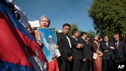 FILE: A supporter of the opposition Cambodia National Rescue Party holds a poster of the party leader Kem Sokha during a rally joined by lawmakers near an appeals court in Phnom Penh, Cambodia, Tuesday, Sept. 26, 2017. 