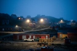 FILE - Early morning fog shrouds homes in Kulusuk, Greenland, Aug. 15, 2019. The Arctic is taking on new geopolitical and economic importance, and not just the United States hopes to stake a claim, with Russia, China and others all wanting in.